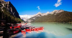 boats on lake louise with snow-capped mountains on the background - 2 weeks in Canada itinerary